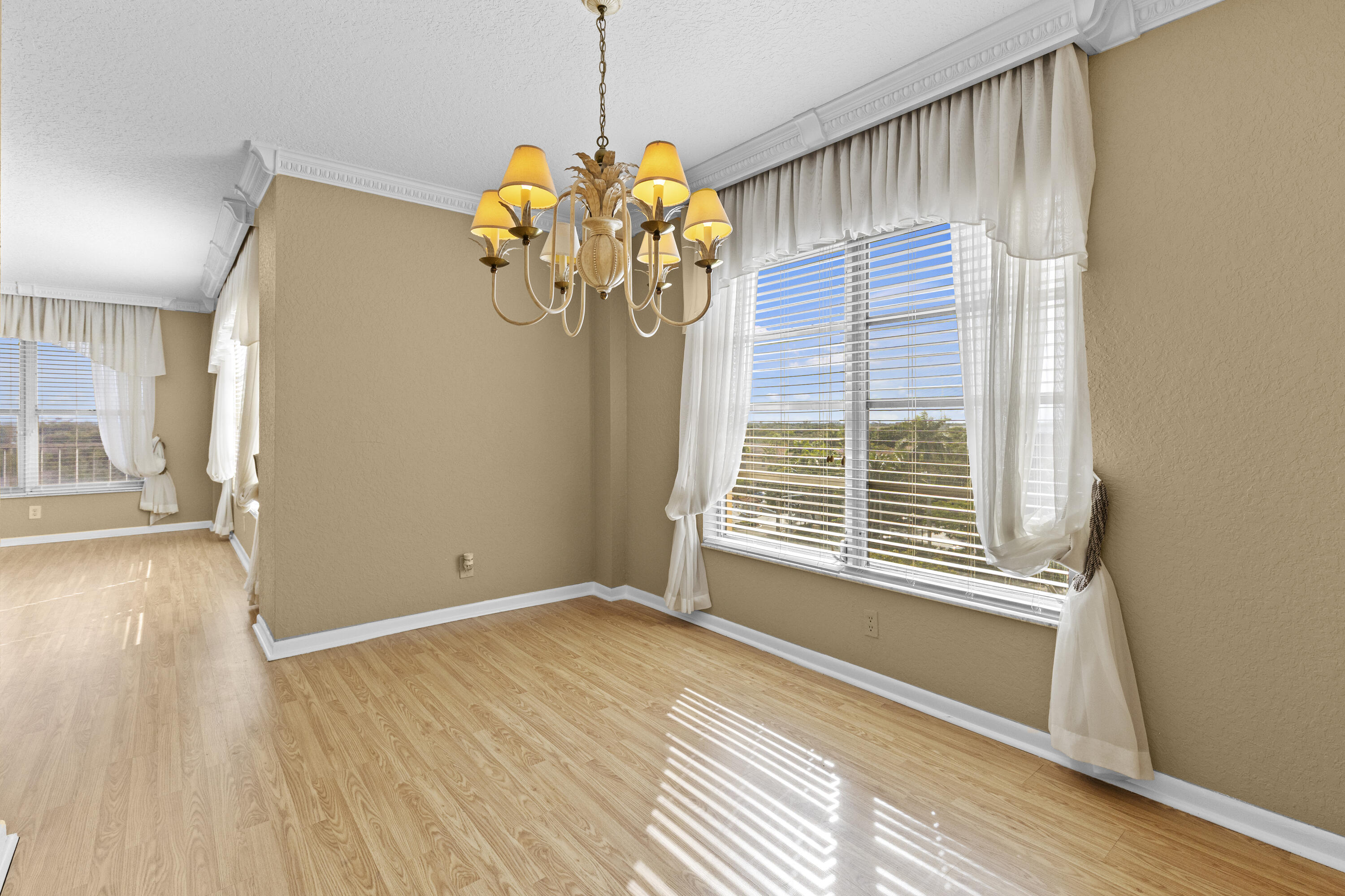 10777 West Sample Road, Unit 719 Coral Springs, FL 33065 - Photo 11 of 44 a view of an empty room with a window and wooden floor