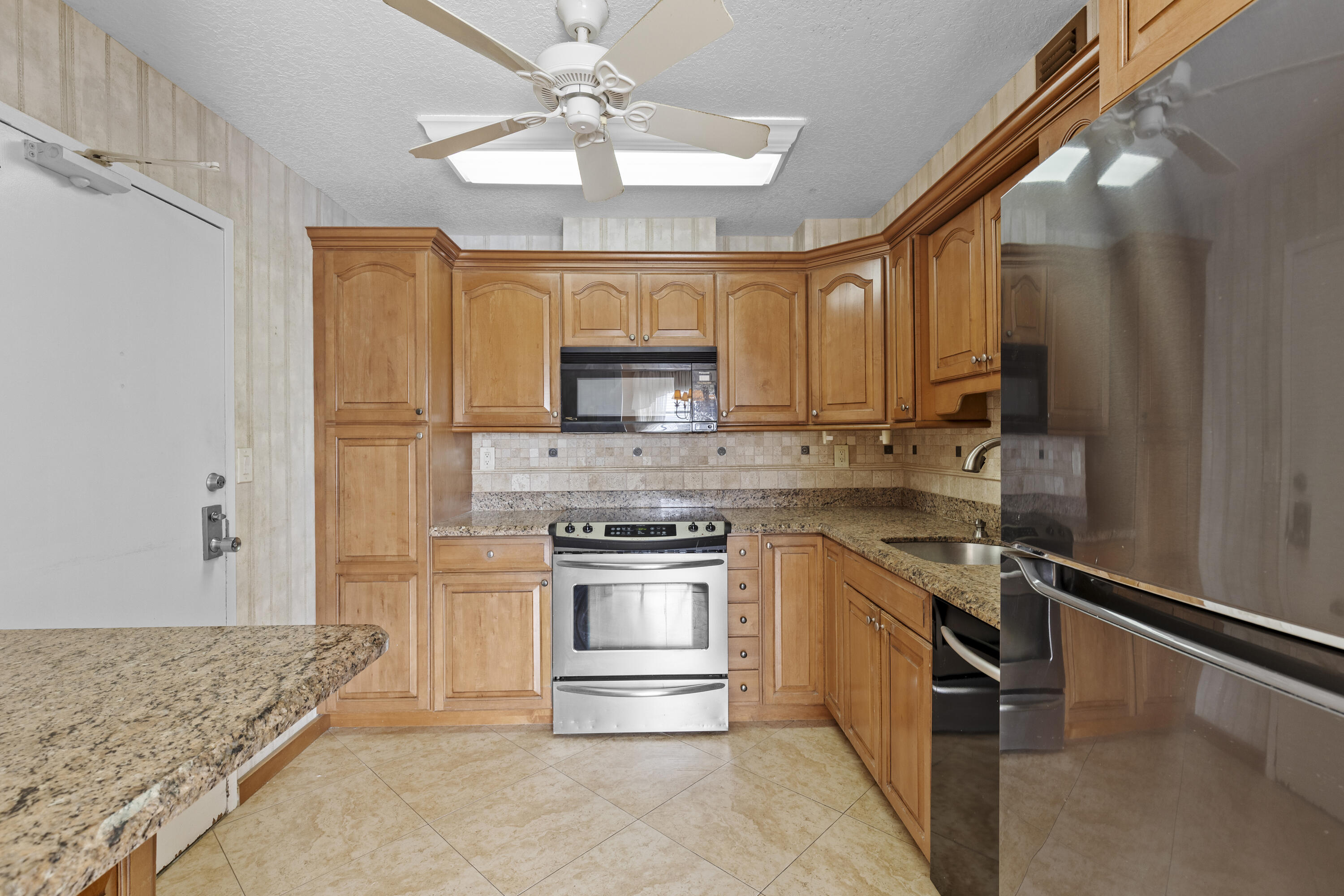 10777 West Sample Road, Unit 719 Coral Springs, FL 33065 - Photo 13 of 44 a kitchen with a stove a sink and a refrigerator