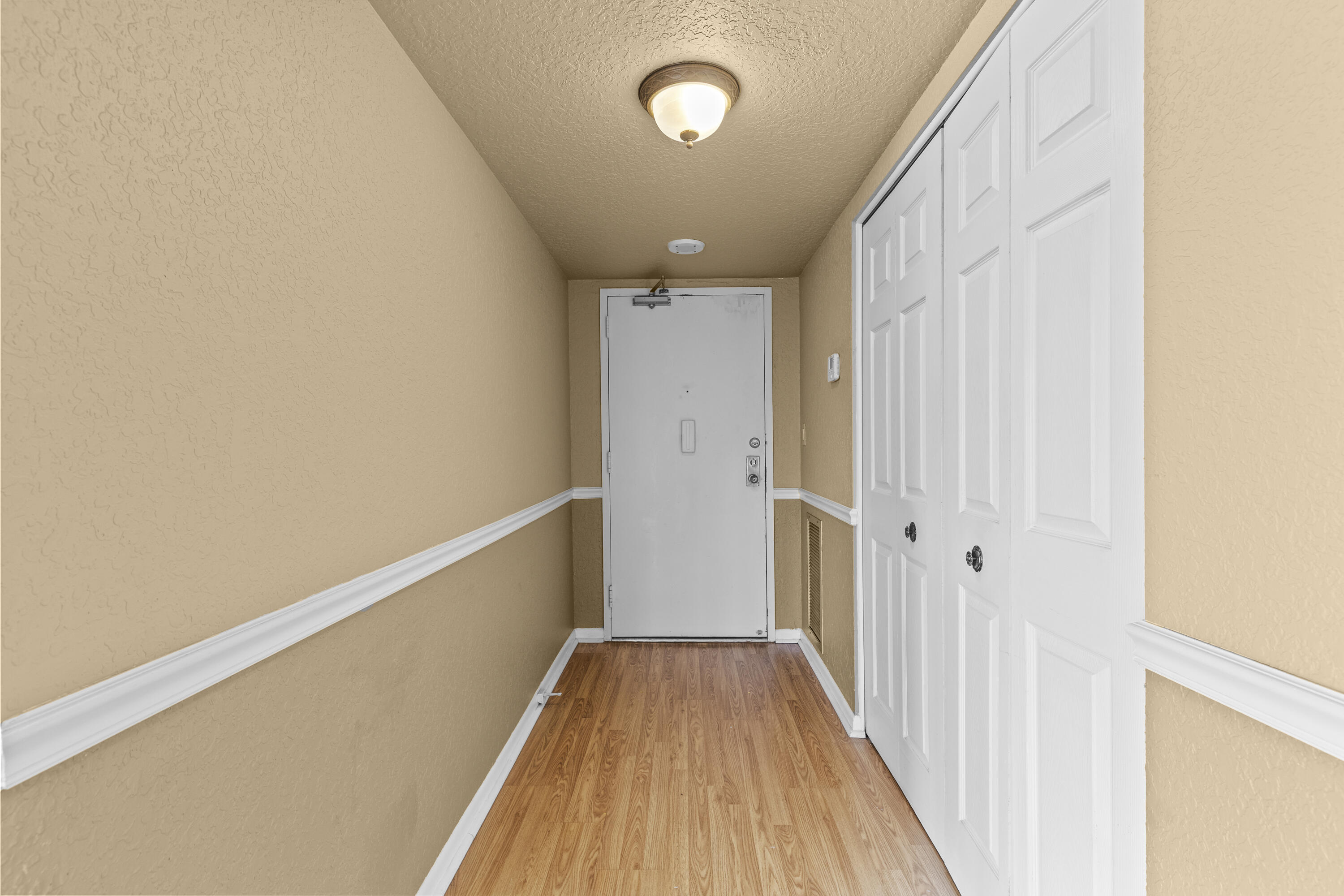 10777 West Sample Road, Unit 719 Coral Springs, FL 33065 - Photo 3 of 44 a view of a hallway with wooden floor