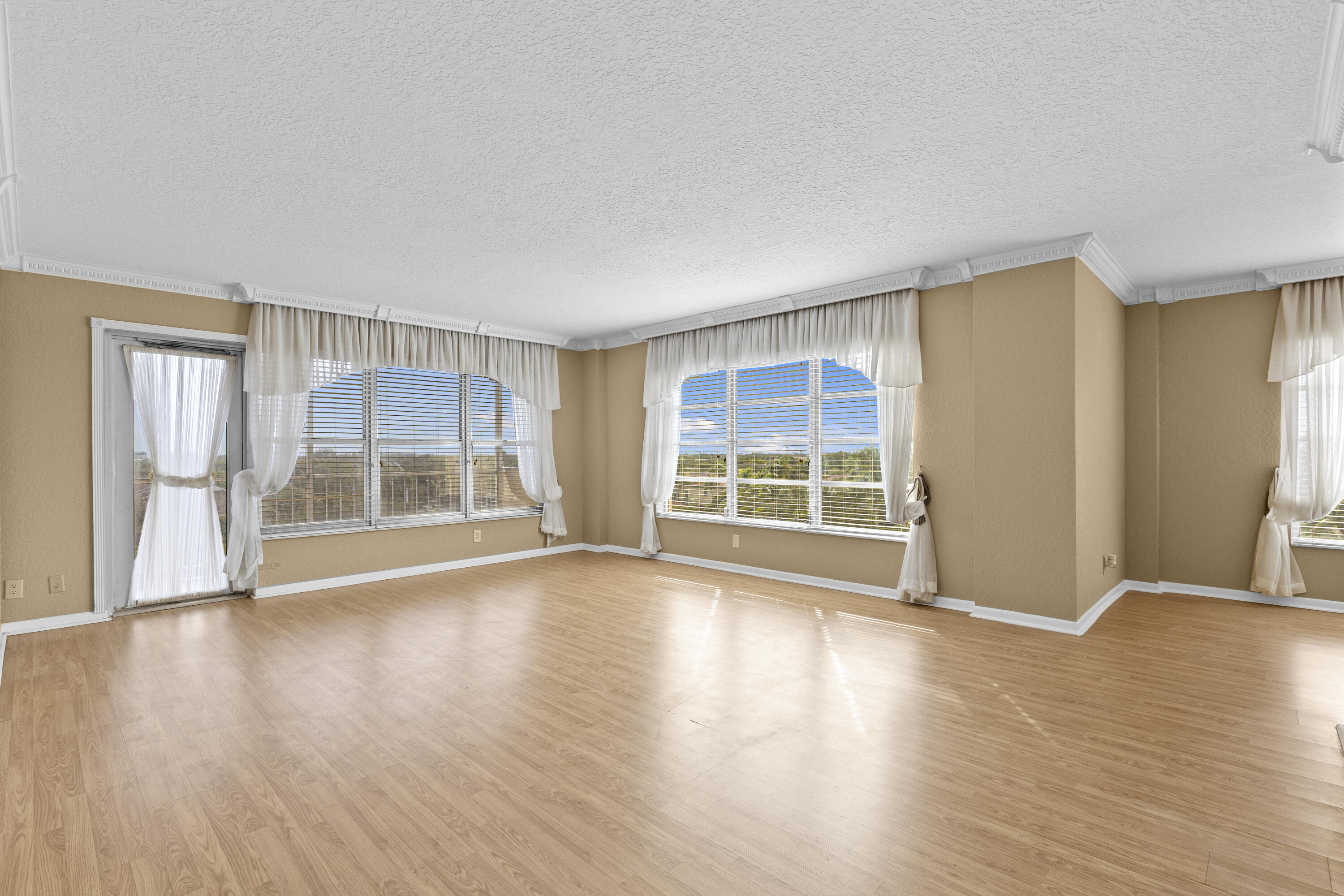 10777 West Sample Road, Unit 719 Coral Springs, FL 33065 - Photo 5 of 44 a view of an empty room with wooden floor and a window