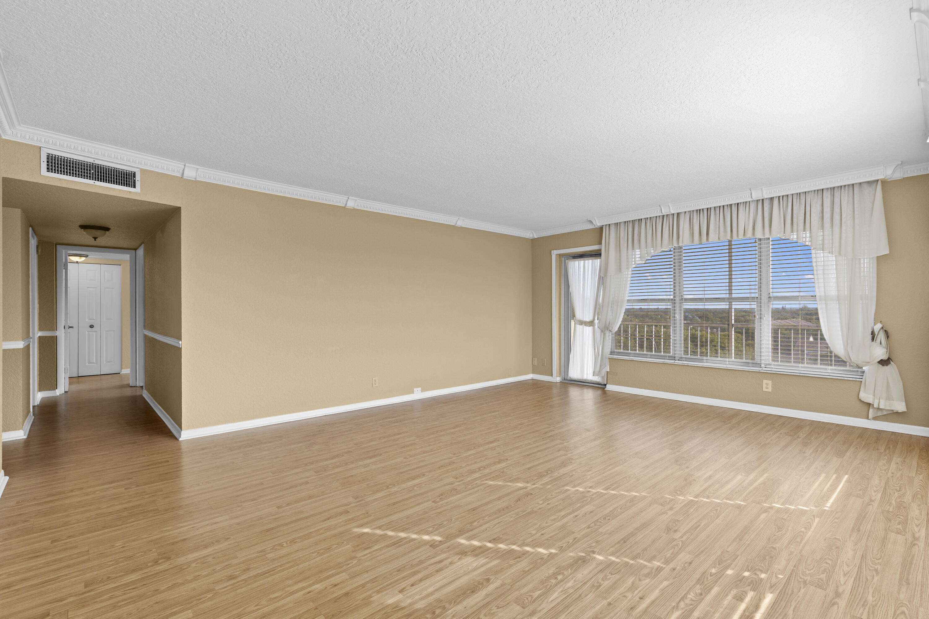 10777 West Sample Road, Unit 719 Coral Springs, FL 33065 - Photo 7 of 44 a view of an empty room with wooden floor and a window