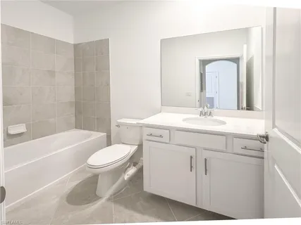 a bathroom with a sink toilet a mirror and bathtub