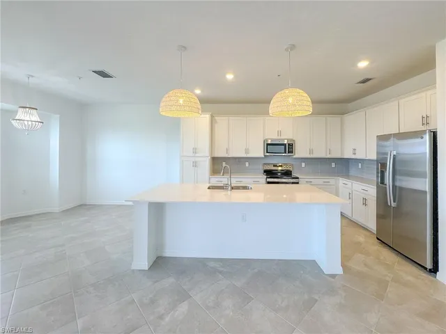 a view of kitchen with cabinets microwave and refrigerator