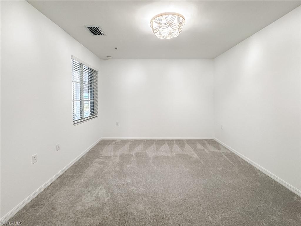 5583 Double Eagle Circle, Unit 4141 Ave Maria, FL 34142 - Photo 22 of 50 an empty room with a empty space and windows