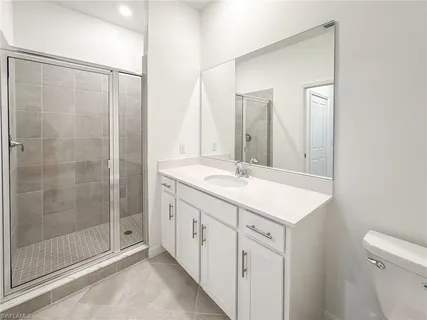 a bathroom with a shower sink and mirror