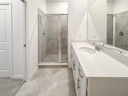 a bathroom with a granite countertop sink a mirror and a shower