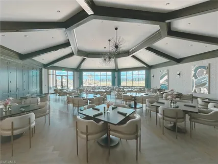 a outdoor space with lots of tables a large window and chairs