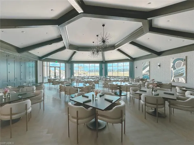 a outdoor space with lots of tables a large window and chairs