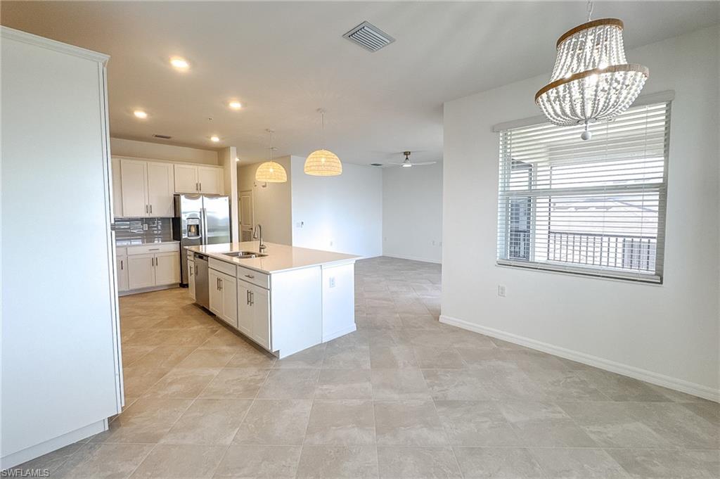 5583 Double Eagle Circle, Unit 4141 Ave Maria, FL 34142 - Photo 50 of 50 a large kitchen with kitchen island granite countertop lots of white cabinets and stainless steel appliances