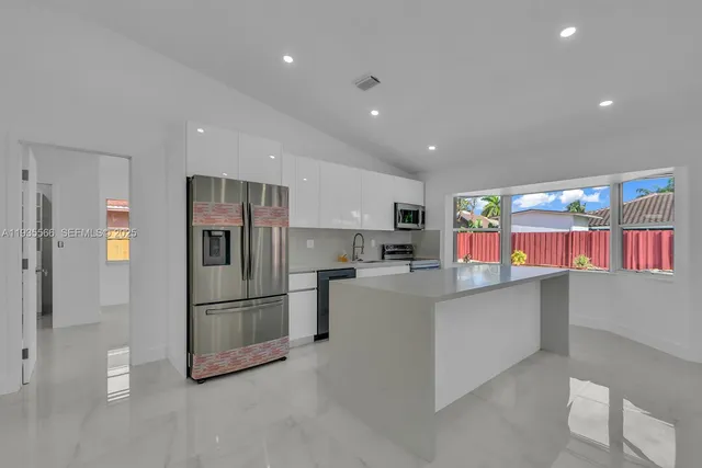 a kitchen with stainless steel appliances a refrigerator and a stove top oven