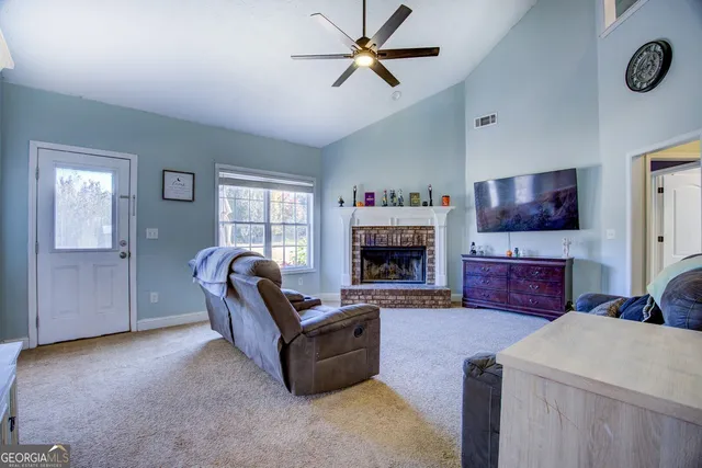a living room with furniture a flat screen tv and a fireplace