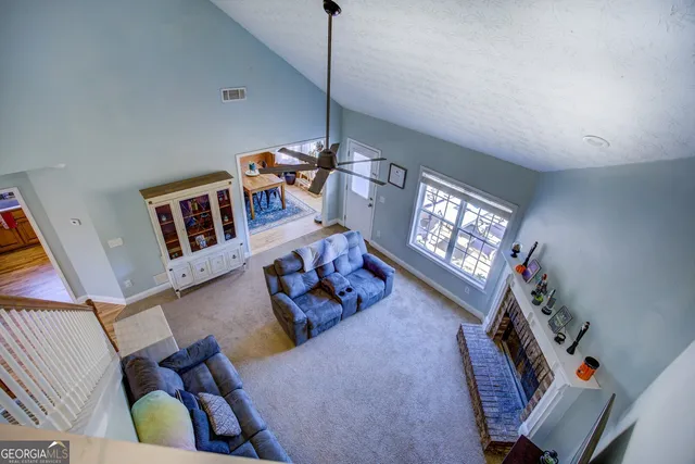 a living room with furniture a bookshelf and a window