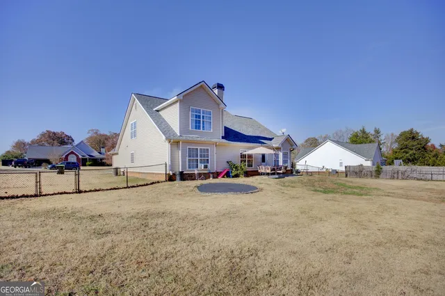 a view of a house with a big yard and large trees
