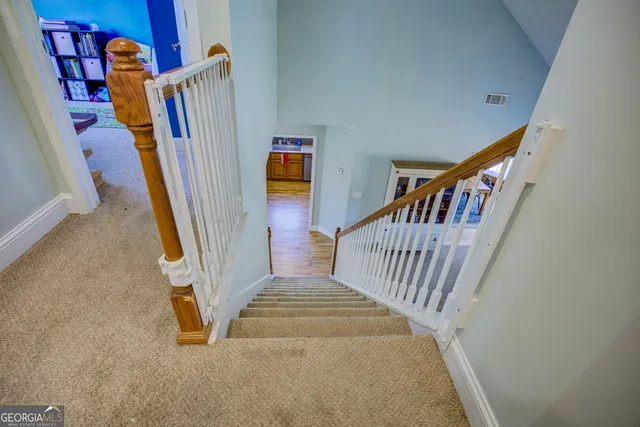 a view of staircase with lots of frames on wall and a window
