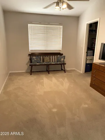 a living room with furniture a flat screen tv and a large window