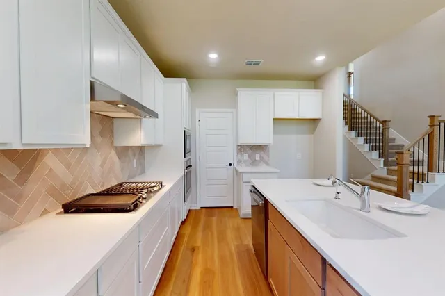 a kitchen with a sink stove and cabinets