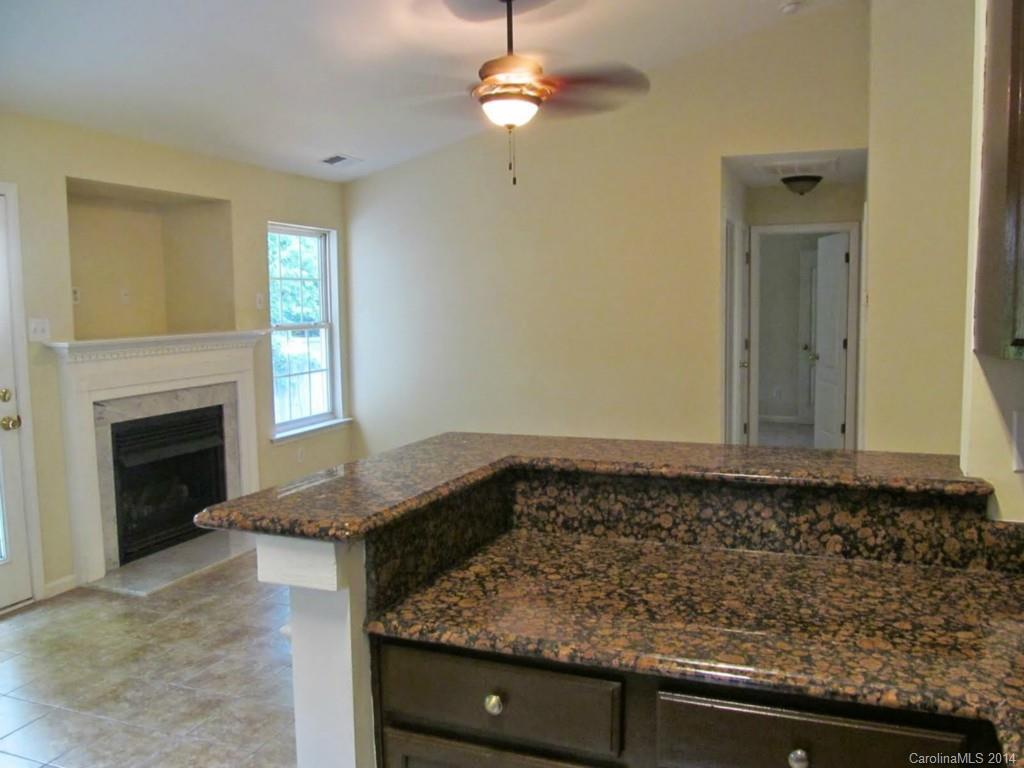 5209 Javitz Road Charlotte, NC 28216 - Photo 4 of 10 a view of a kitchen sink dishwasher and fireplace with wooden floor