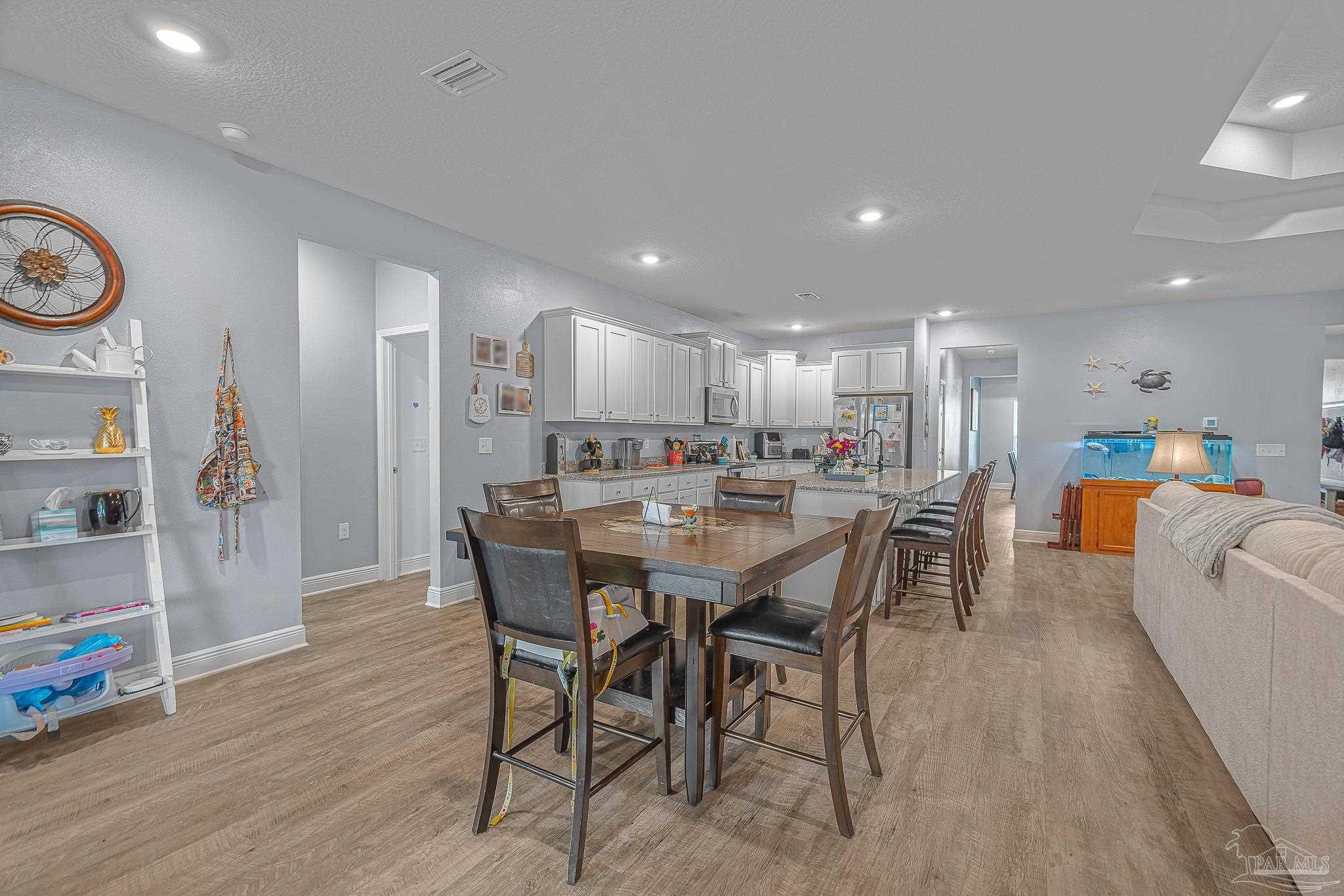 355 Cayden Way Cantonment, FL 32533 - Photo 18 of 61 a dining area with stainless steel appliances kitchen island granite countertop a dining table chairs and a refrigerator