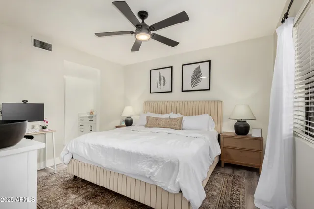 a bedroom with a bed a couch and a ceiling fan