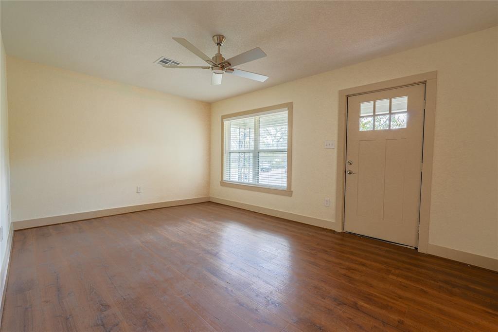 2701 McKenzie Avenue Waco, TX 76708 - Photo 5 of 19 a view of an empty room with wooden floor and a window