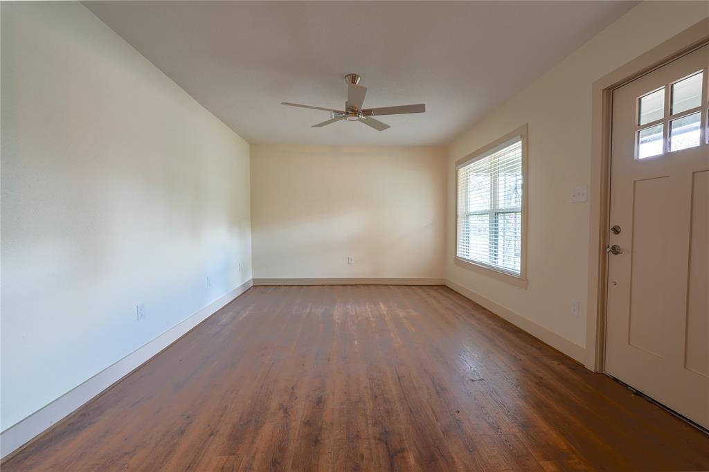 2701 McKenzie Avenue Waco, TX 76708 - Photo 6 of 19 an empty room with wooden floor windows and ceiling fan