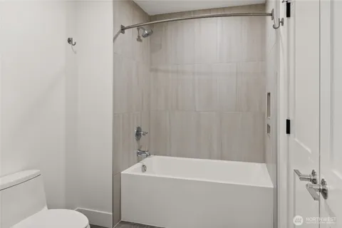 a white bath tub sitting next to a white toilet and a shower