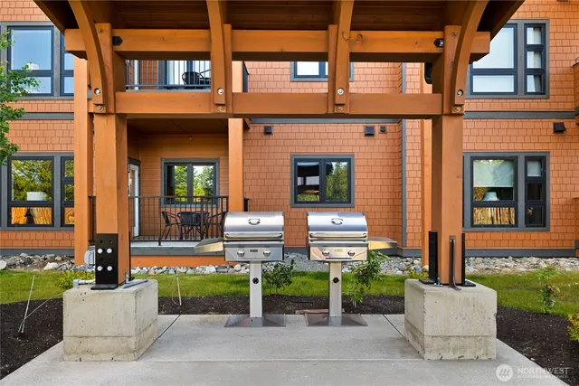 front view of a brick house with a chairs and table in a patio