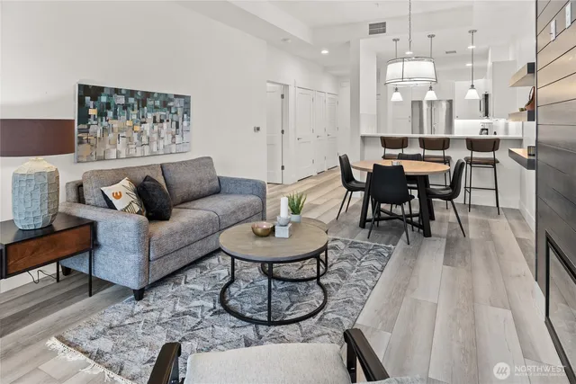 a living room with furniture and a dining table with wooden floor