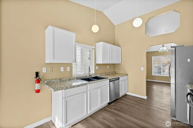 a kitchen with stainless steel appliances granite countertop a stove a microwave and a refrigerator