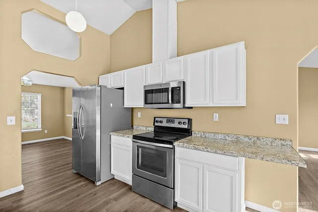 a kitchen with granite countertop a sink stainless steel appliances and cabinets