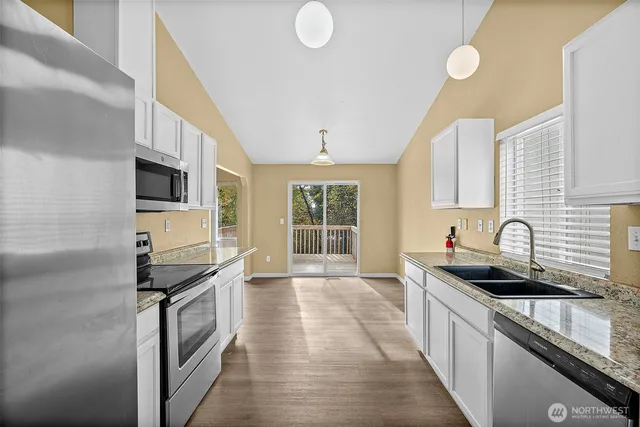 a view of an empty room with window and wooden floor