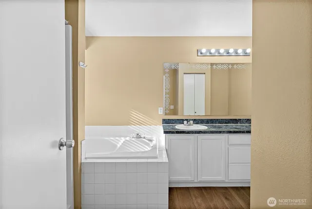 a bathroom with a granite countertop sink and a mirror
