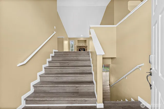 a view of empty room with fireplace and wooden floor