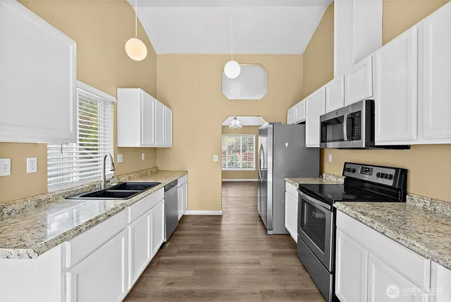 a kitchen with a sink cabinets and wooden floor