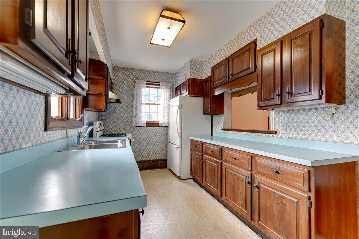 327 North Rolling Road Springfield, PA 19064 - Photo 13 of 34 a kitchen with stainless steel appliances granite countertop a sink stove and cabinets