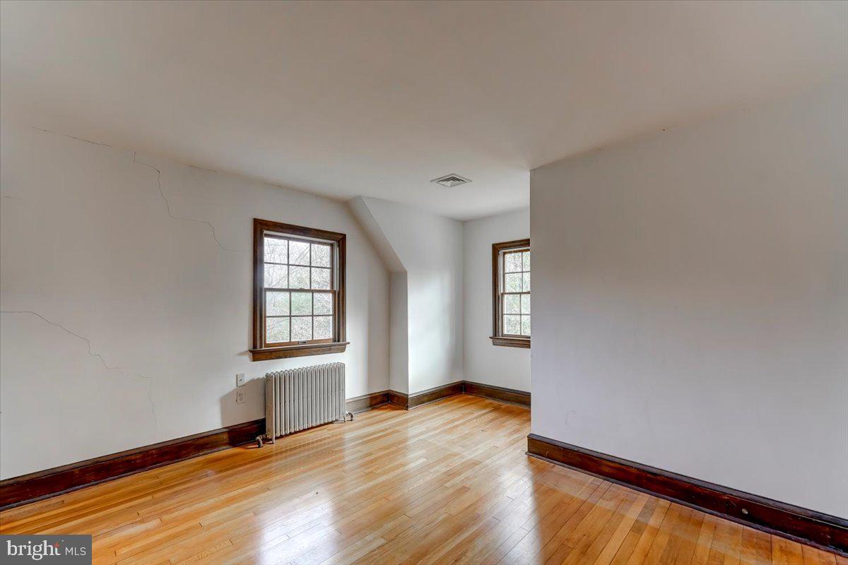 327 North Rolling Road Springfield, PA 19064 - Photo 22 of 34 an empty room with wooden floor and windows
