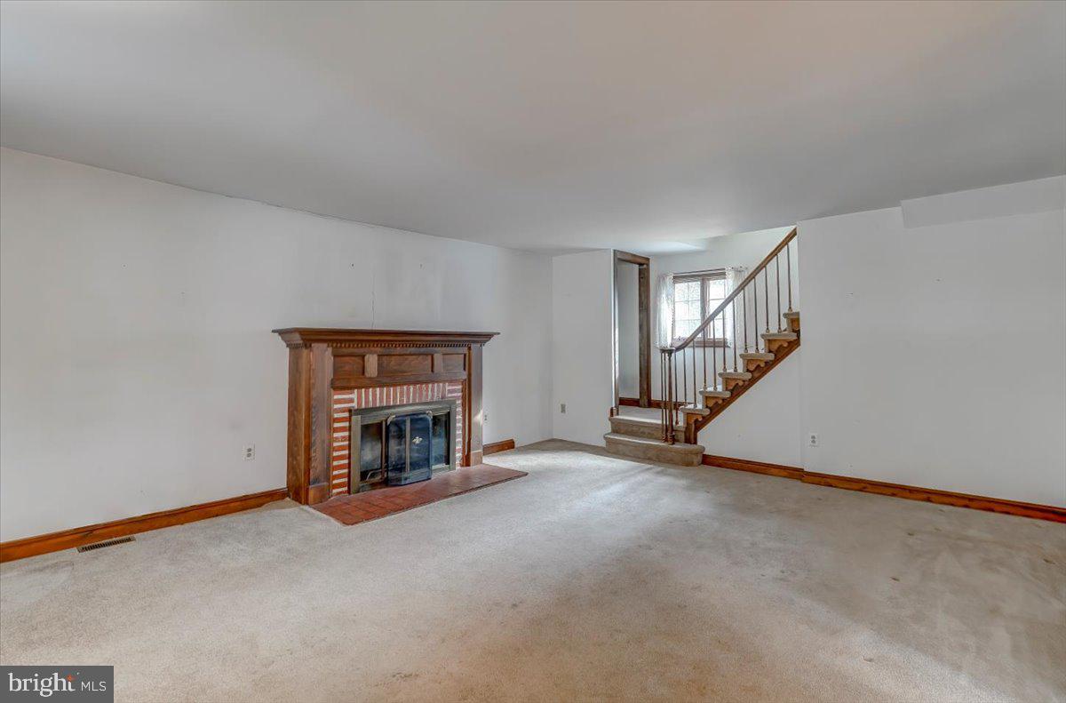 327 North Rolling Road Springfield, PA 19064 - Photo 4 of 34 a view of an empty room with fireplace and stairs