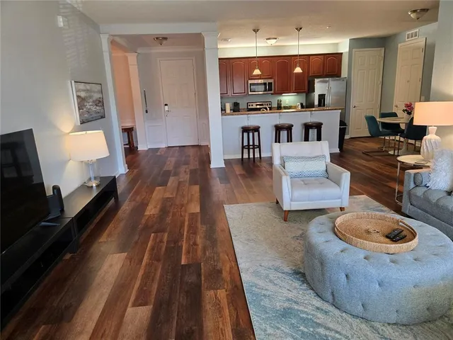 a living room with furniture and a wooden floor