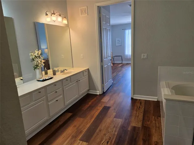 a bathroom with a double vanity sink and mirror with shower