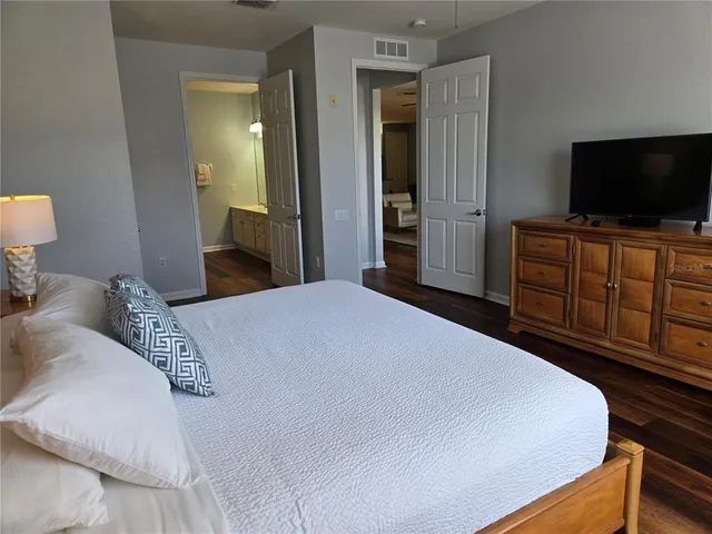 a bedroom with a flat screen tv and a bed