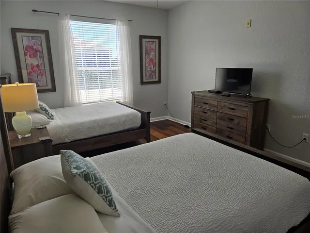 a bedroom with two beds and a window