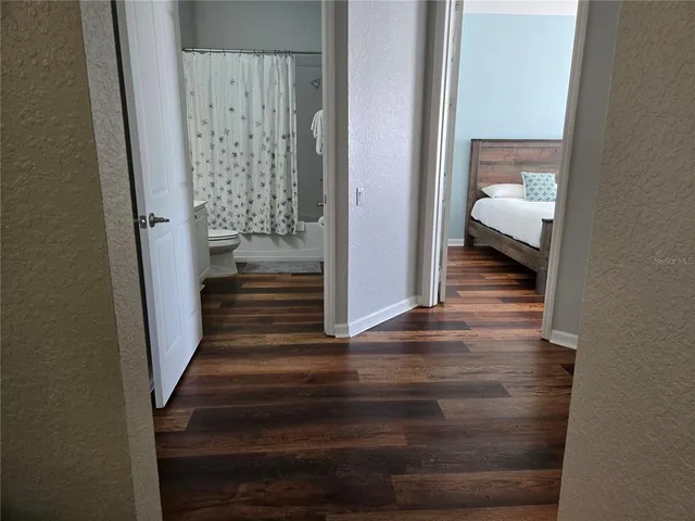 a view of a hallway with wooden floor and entryway