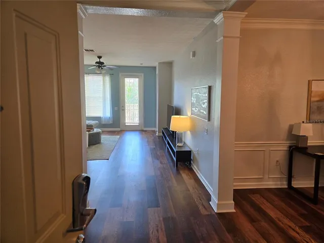 a view of a hallway with wooden floor and a lamp