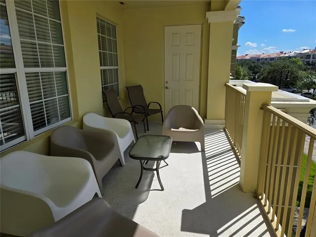 a balcony with chairs and a potted plant