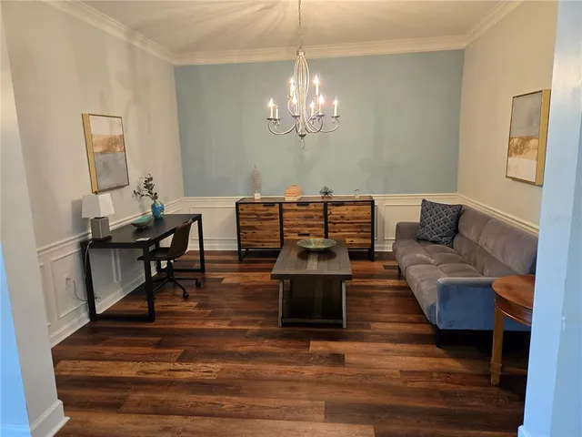 a living room with furniture and a chandelier
