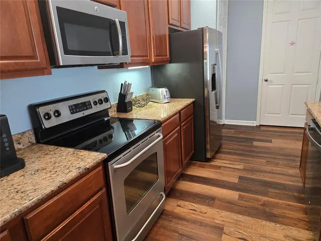 a kitchen with stainless steel appliances granite countertop a stove microwave and refrigerator