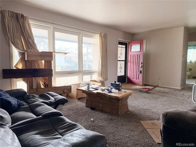 a living room with furniture fireplace and a large window