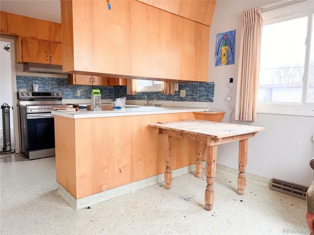 a kitchen with stainless steel appliances granite countertop a stove and a refrigerator