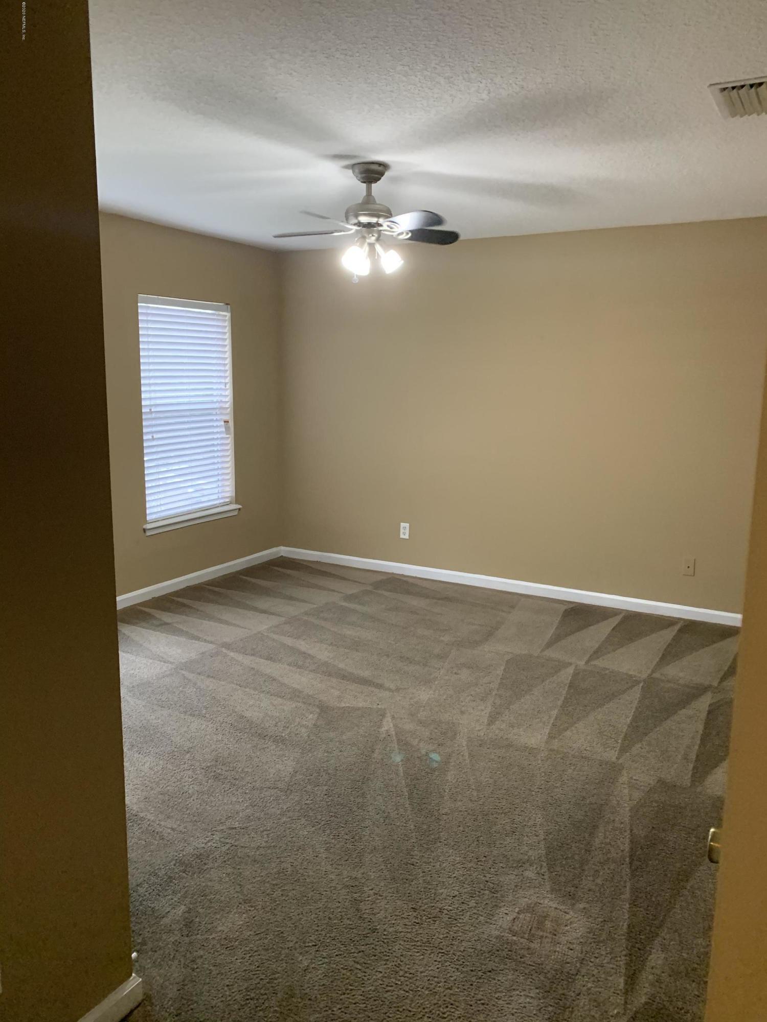 7140 Rampart Ridge Circle West Jacksonville, FL 32244 - Photo 5 of 13 a view of an empty room with window and chandelier fan