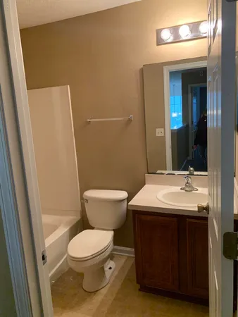 a bathroom with a toilet a sink and a mirror